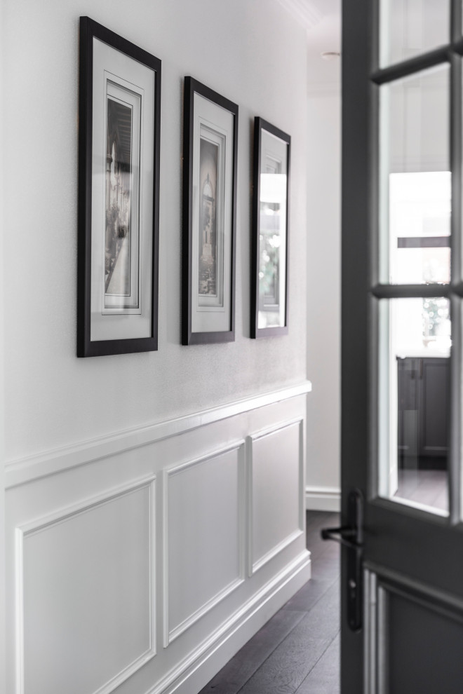 Inspiration pour une porte d'entrée traditionnelle de taille moyenne avec un mur blanc, une porte simple, une porte noire et un sol marron.