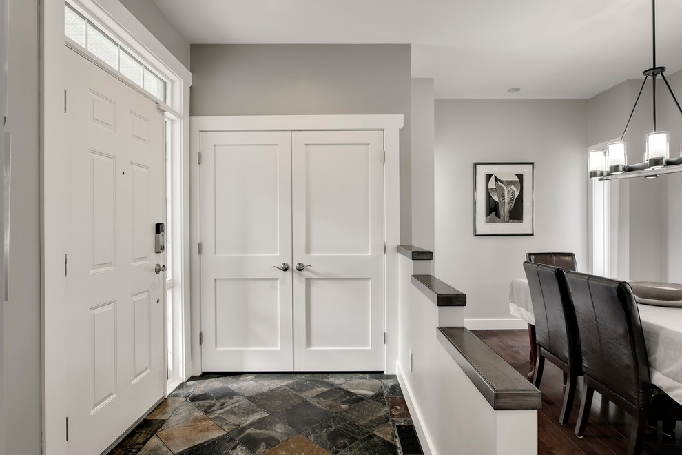 Inspiration for a mid-sized transitional slate floor and multicolored floor front door remodel in Calgary with gray walls and a white front door