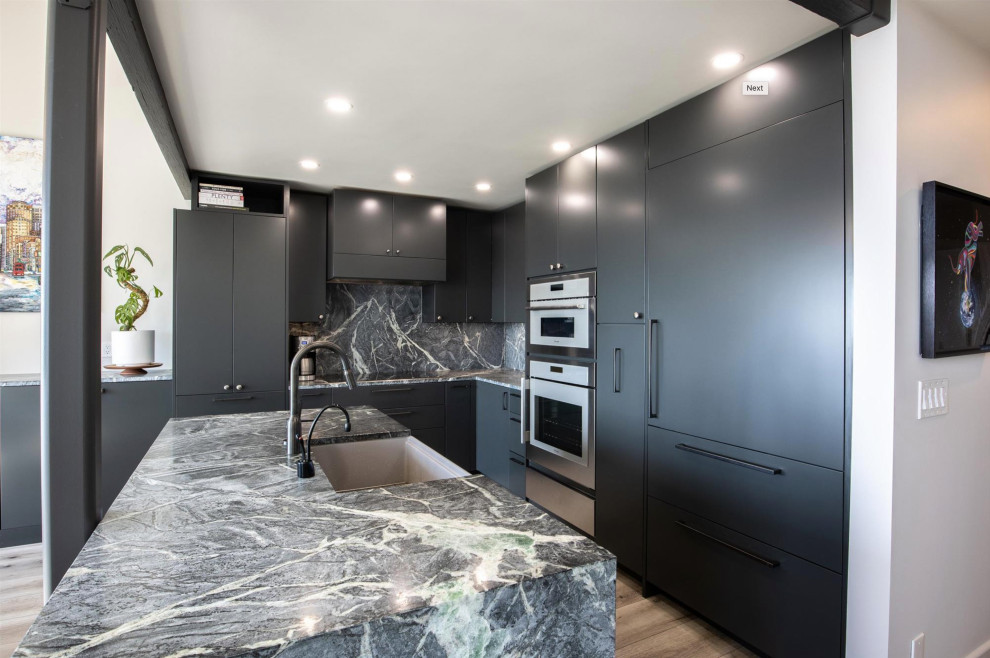 Photo of a small contemporary l-shaped eat-in kitchen in San Francisco with a farmhouse sink, flat-panel cabinets, black cabinets, soapstone benchtops, multi-coloured splashback, black appliances, vinyl floors, with island, brown floor, multi-coloured benchtop and vaulted.