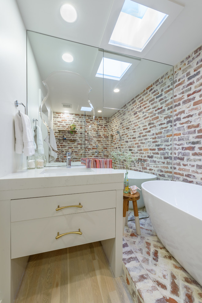 Inspiration for a small contemporary master bathroom in Dallas with flat-panel cabinets, white cabinets, a freestanding tub, a shower/bathtub combo, a two-piece toilet, multi-coloured tile, multi-coloured walls, light hardwood floors, a console sink, marble benchtops, beige floor and an open shower.