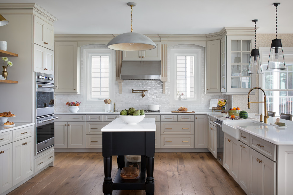 Example of a beach style u-shaped light wood floor kitchen design in Other with a farmhouse sink and ceramic backsplash