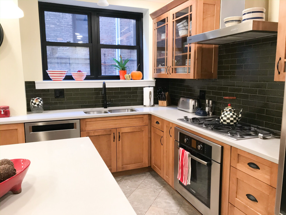 Example of a mid-sized transitional l-shaped eat-in kitchen design in Chicago with an undermount sink, shaker cabinets, brown cabinets, green backsplash, stainless steel appliances, an island and gray countertops