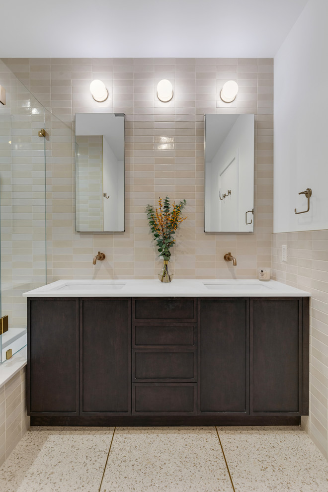 Photo of a transitional master bathroom in New York with shaker cabinets, dark wood cabinets, a drop-in tub, multi-coloured tile, ceramic tile, terrazzo floors, engineered quartz benchtops and white benchtops.