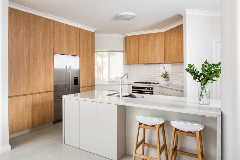 Mid-sized contemporary l-shaped eat-in kitchen in Perth with a double-bowl sink, flat-panel cabinets, grey cabinets, quartz benchtops, white splashback, subway tile splashback, stainless steel appliances, ceramic floors, with island, beige floor and white benchtop.