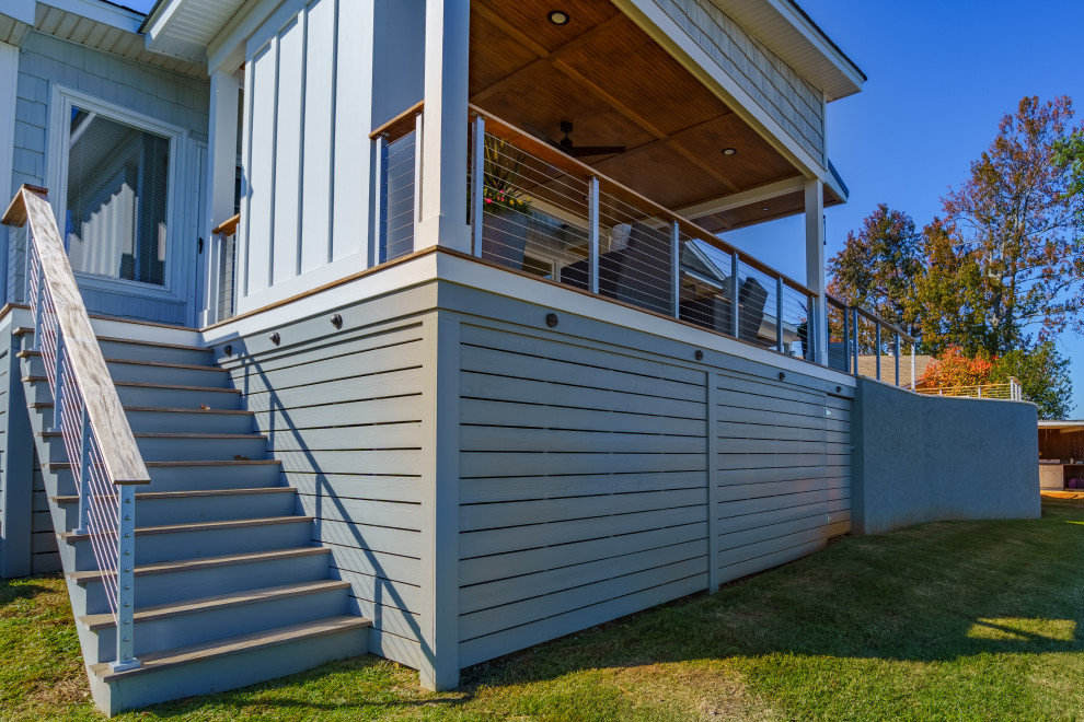Inspiration för mellanstora maritima verandor på baksidan av huset, med takförlängning och räcke i trä