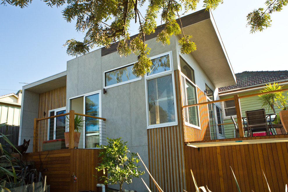 Photo of a mid-sized contemporary one-storey grey exterior in Melbourne with mixed siding and a flat roof.