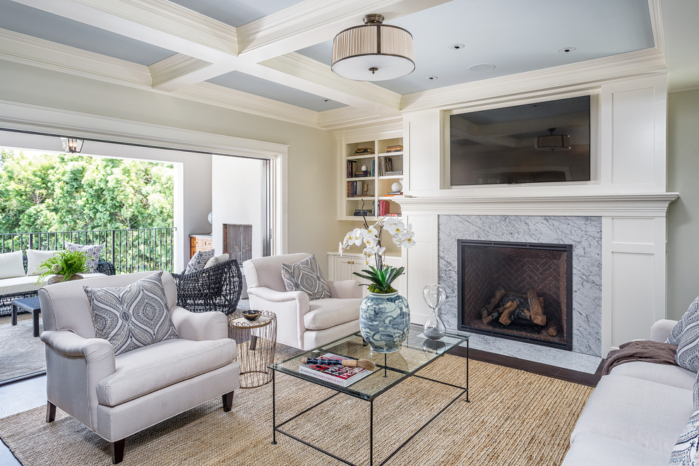 Photo of a traditional family room in Los Angeles with a library, grey walls, a standard fireplace and a wall-mounted tv.