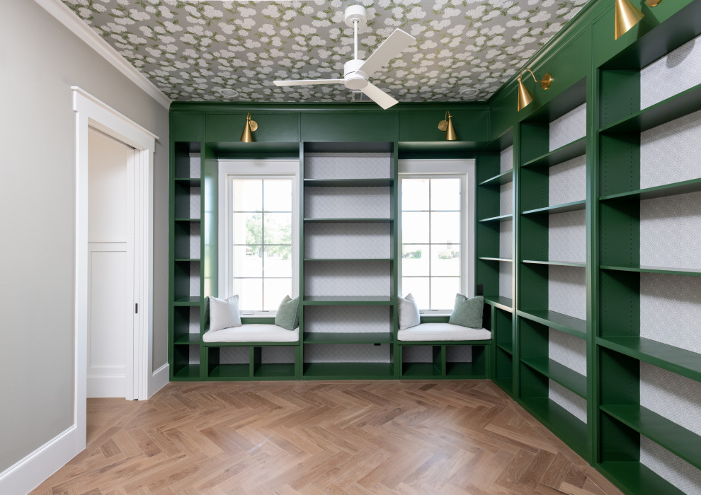 Lantlig inredning av ett mellanstort separat vardagsrum, med ett bibliotek, grå väggar, ljust trägolv och brunt golv