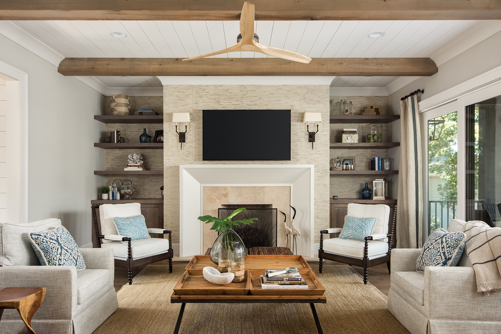 Photo of a beach style family room in Charlotte with grey walls, dark hardwood floors, a standard fireplace, a stone fireplace surround and a wall-mounted tv.