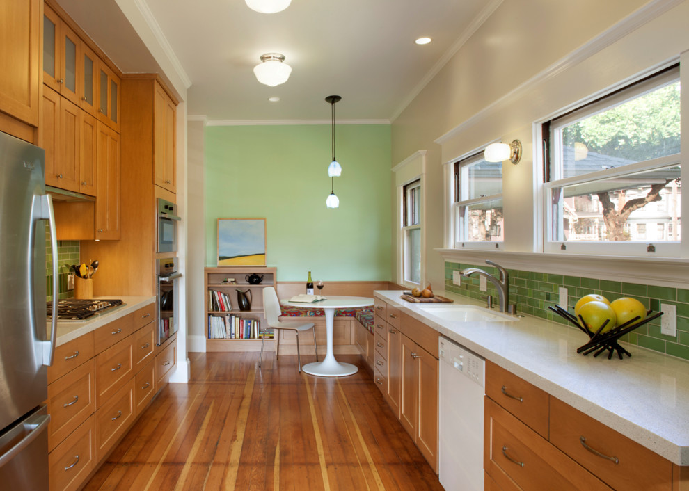 Inspiration for a mid-sized traditional galley eat-in kitchen in San Francisco with a single-bowl sink, shaker cabinets, medium wood cabinets, granite benchtops, green splashback, subway tile splashback, stainless steel appliances, dark hardwood floors and no island.