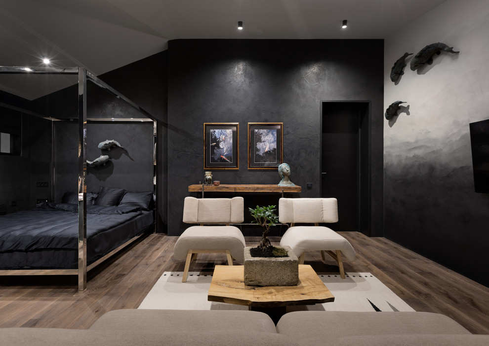 This is an example of an asian bedroom in Other with black walls, medium hardwood floors and brown floor.