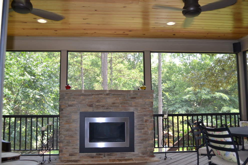 This is an example of a modern deck in Charlotte with a fire feature and a roof extension.