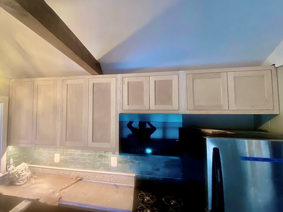 Inspiration for a beach style single-wall kitchen in Boston with shaker cabinets and exposed beam.