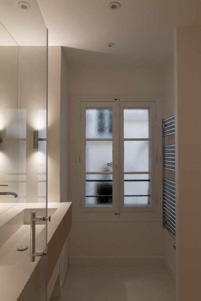 Idéer för ett mellanstort modernt vit badrum med dusch, med luckor med profilerade fronter, vita skåp, en kantlös dusch, vita väggar, betonggolv, ett konsol handfat, bänkskiva i betong, vitt golv och dusch med gångjärnsdörr