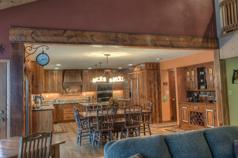 Eat-in kitchen - rustic u-shaped eat-in kitchen idea with an undermount sink, raised-panel cabinets, medium tone wood cabinets, granite countertops and stainless steel appliances