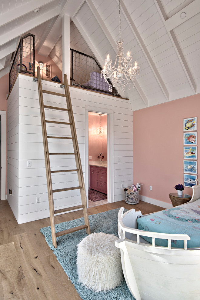 This is an example of a large transitional kids' bedroom for kids 4-10 years old and girls in Austin with pink walls, light hardwood floors and brown floor.