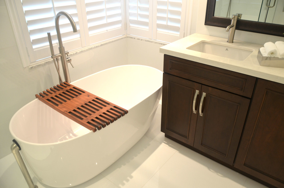 Design ideas for a mid-sized modern bathroom in Miami with an undermount sink, flat-panel cabinets, dark wood cabinets, quartzite benchtops, a freestanding tub, white tile, white walls and porcelain floors.