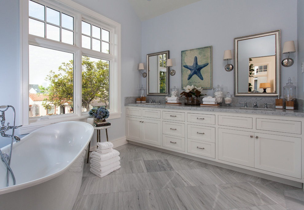 Inspiration for a beach style master bathroom in Orange County with shaker cabinets, white cabinets, a freestanding tub, blue walls and an undermount sink.