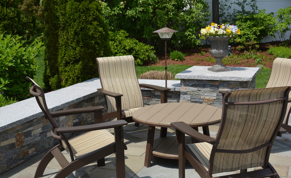 Inspiration for a country backyard patio in Boston with natural stone pavers.