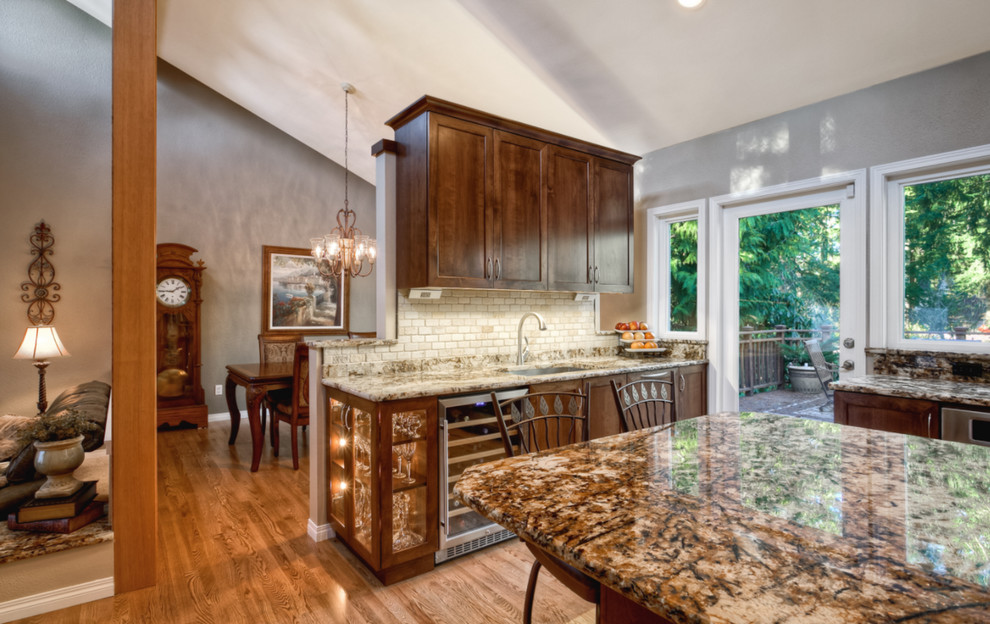 Large arts and crafts u-shaped separate kitchen in Seattle with an undermount sink, granite benchtops, beige splashback, stainless steel appliances, medium hardwood floors, with island, shaker cabinets, brown floor, dark wood cabinets and stone tile splashback.