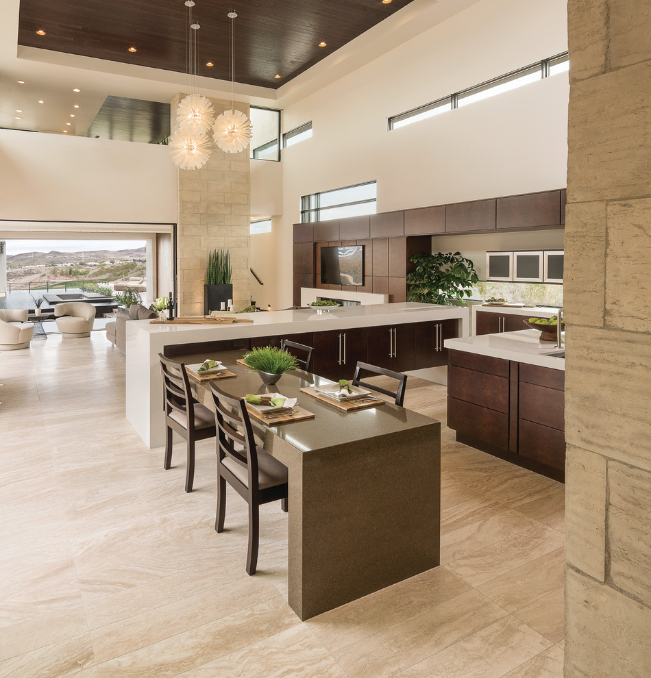 Expansive contemporary l-shaped open plan kitchen in Las Vegas with an undermount sink, flat-panel cabinets, dark wood cabinets, stainless steel appliances, multiple islands, beige floor and white benchtop.