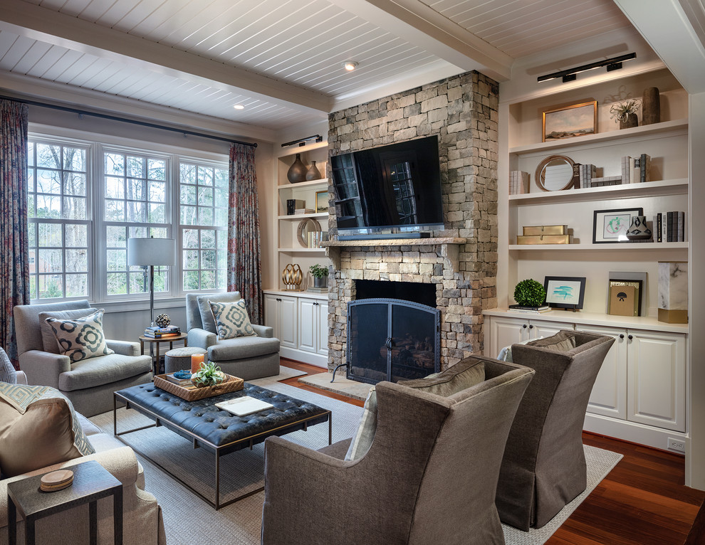 Photo of a mid-sized traditional open concept family room in Atlanta with white walls, a standard fireplace, a stone fireplace surround, a wall-mounted tv, brown floor and dark hardwood floors.