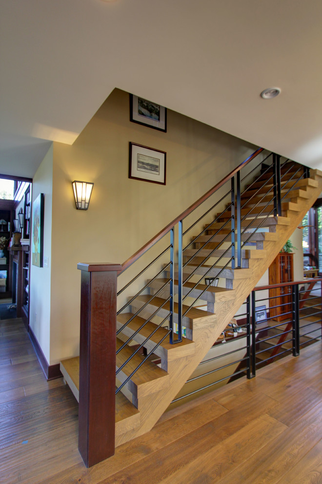 Photo of a mid-sized transitional wood floating staircase in Seattle with open risers and metal railing.