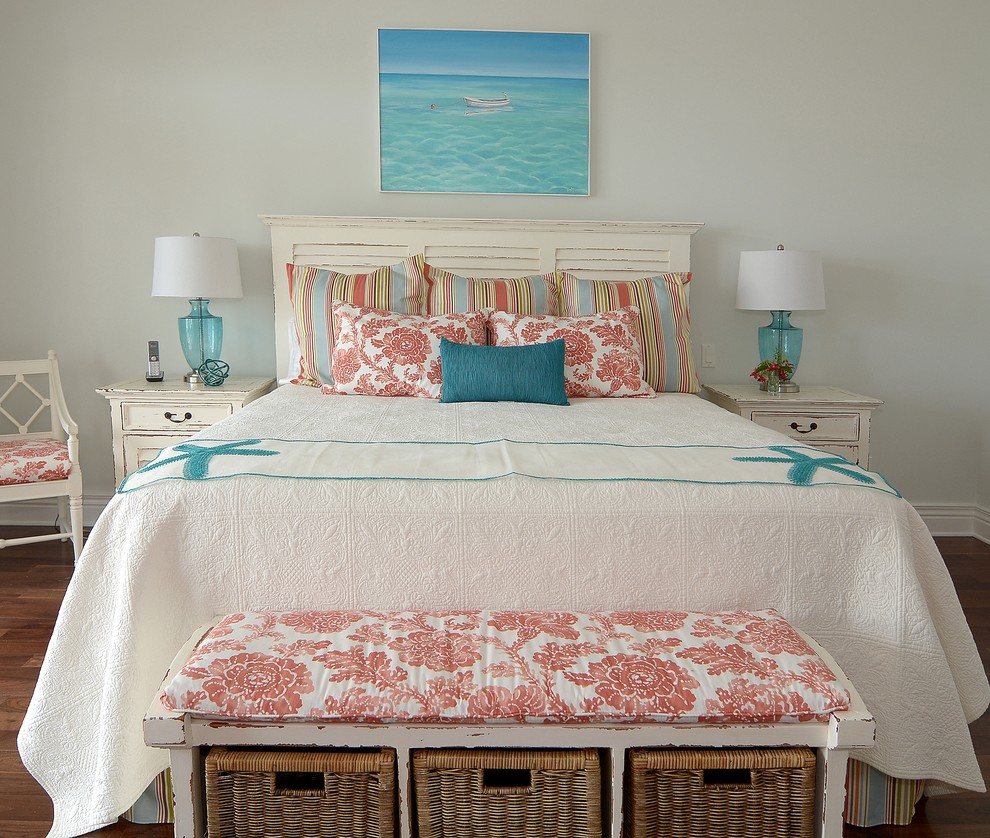 Inspiration for a beach style master bedroom in Miami with beige walls and medium hardwood floors.
