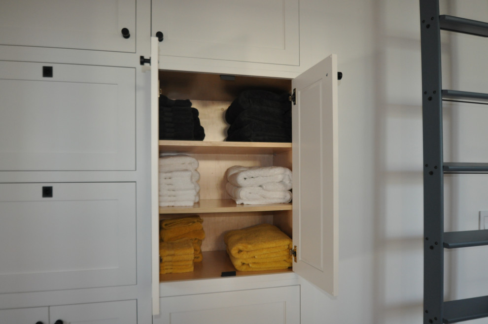 Imagen de armario y vestidor clásico renovado pequeño con a medida, armarios con paneles empotrados, puertas de armario blancas, suelo de madera oscura y suelo marrón
