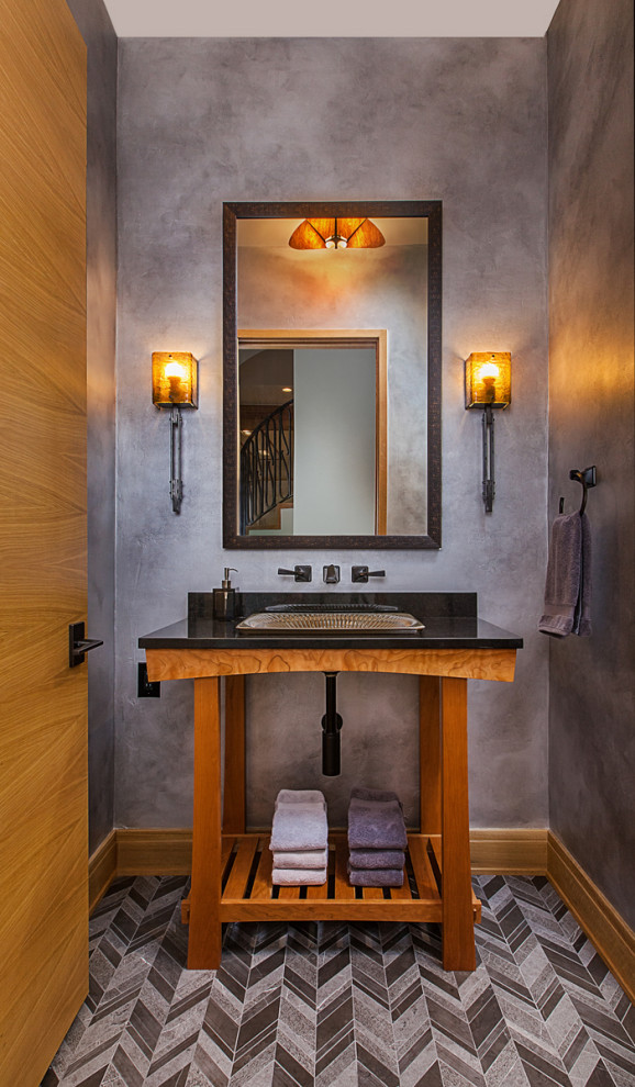 Foto på ett litet eklektiskt svart toalett, med skåp i mellenmörkt trä, en toalettstol med separat cisternkåpa, grå väggar, klinkergolv i porslin, ett fristående handfat, granitbänkskiva och grått golv