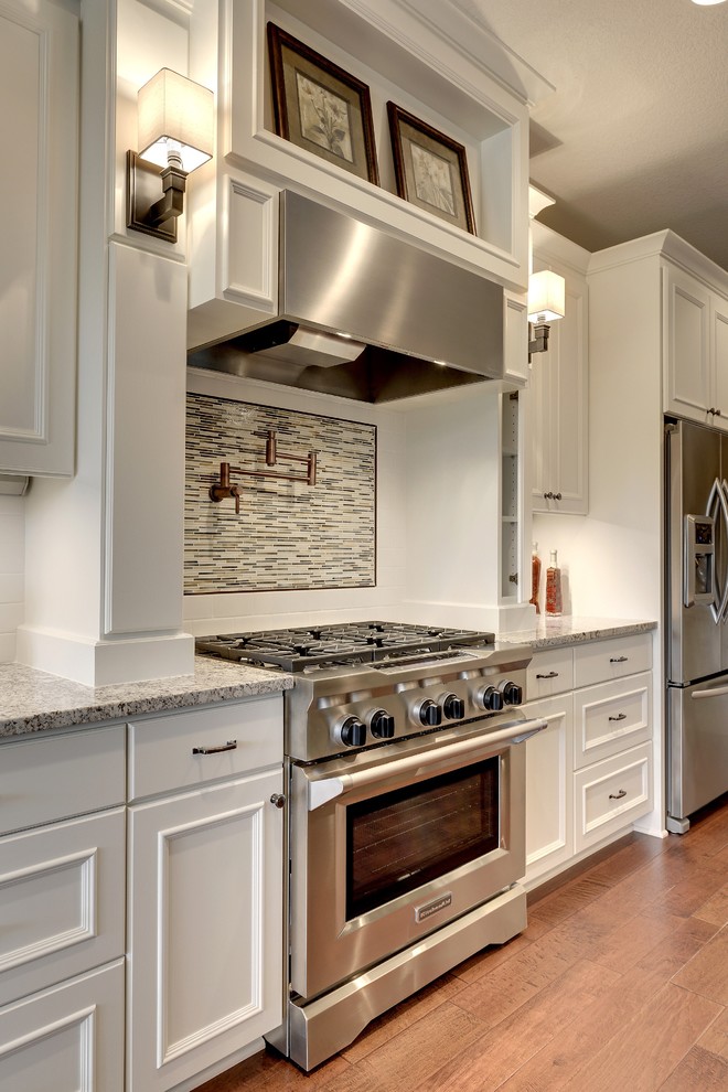 Design ideas for a traditional kitchen in Minneapolis with granite benchtops, white splashback, subway tile splashback and stainless steel appliances.