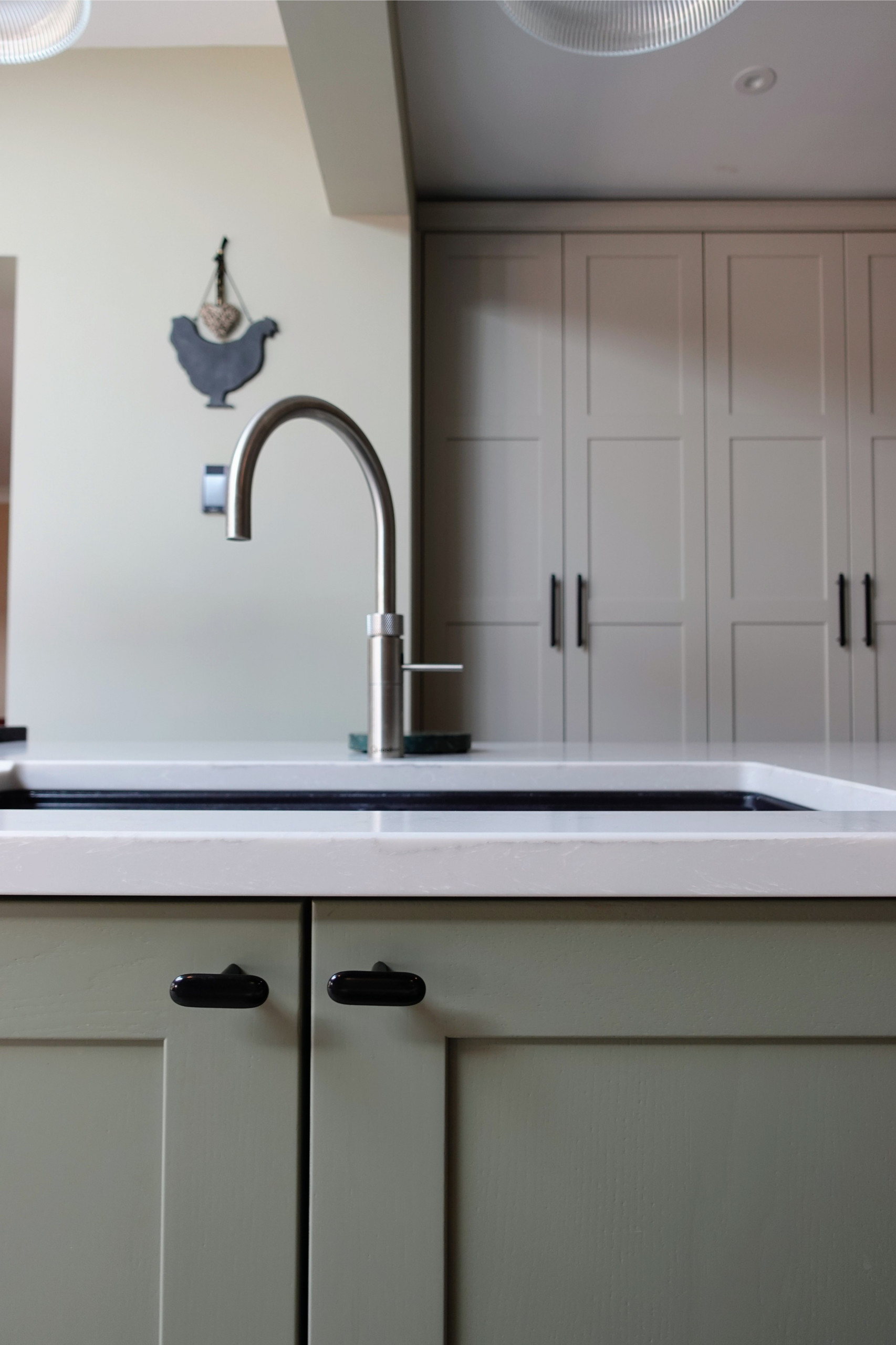 Large transitional vinyl floor and brown floor open concept kitchen photo in West Midlands with a double-bowl sink, shaker cabinets, distressed cabinets, quartzite countertops, white backsplash, quart