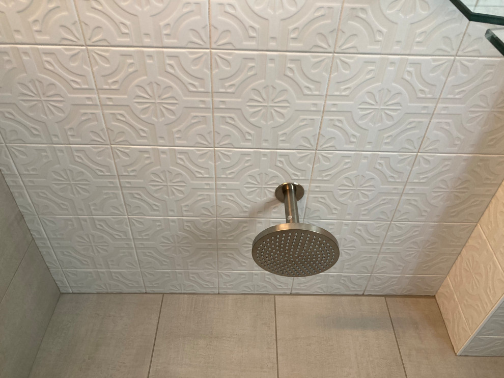 Cette image montre une salle de bain minimaliste de taille moyenne avec un sol gris, une cabine de douche à porte battante et un banc de douche.