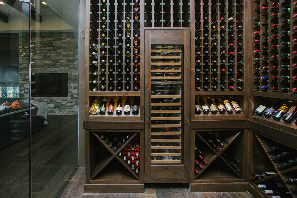 This is an example of a mid-sized transitional wine cellar in Portland with dark hardwood floors, storage racks and brown floor.