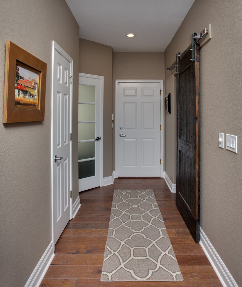 Inspiration for a large transitional hallway in Denver with beige walls and medium hardwood floors.