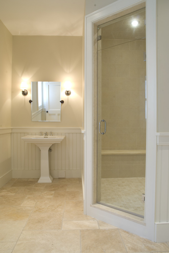 This is an example of a large traditional master bathroom in Boston with a corner shower, beige walls, a pedestal sink, beige floor and a hinged shower door.