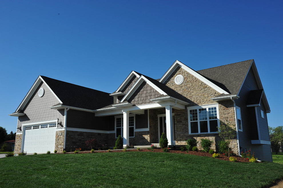 This is an example of a large arts and crafts one-storey brown exterior in Chicago with vinyl siding and a gable roof.