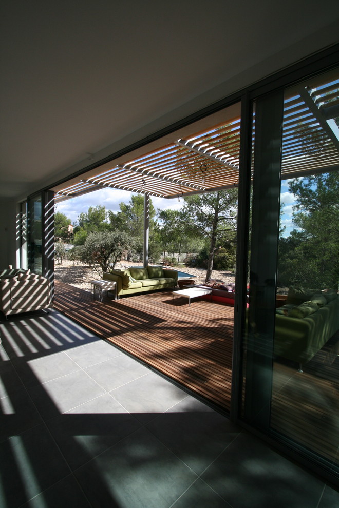 Large contemporary backyard deck in Montpellier with an awning.