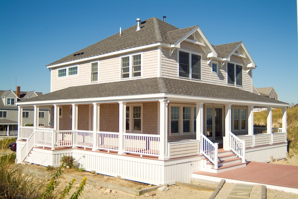 Inspiration for a large beach style two-storey beige exterior in Boston with wood siding and a gable roof.