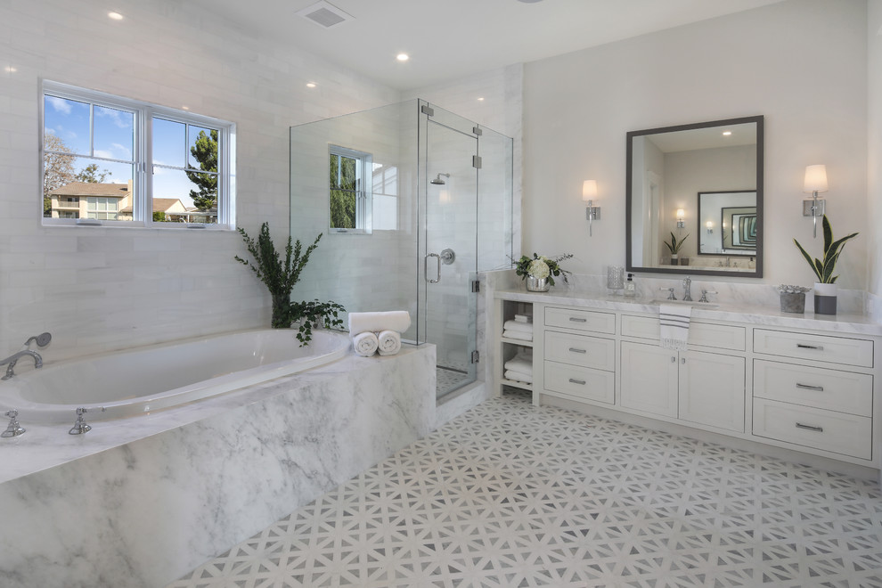 Transitional master bathroom in Orange County with shaker cabinets, white cabinets, a drop-in tub, a corner shower, white tile, grey walls, an undermount sink, grey floor, a hinged shower door and white benchtops.