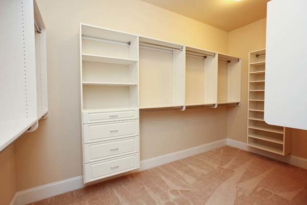 Design ideas for a large traditional gender-neutral walk-in wardrobe in Charlotte with raised-panel cabinets, white cabinets and carpet.