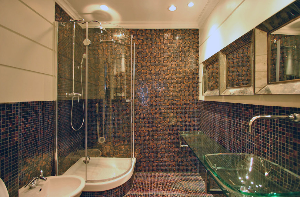 This is an example of a large contemporary master bathroom in Rome with a drop-in sink, glass-front cabinets, glass benchtops, a corner shower, a wall-mount toilet, brown tile, mosaic tile, brown walls and mosaic tile floors.