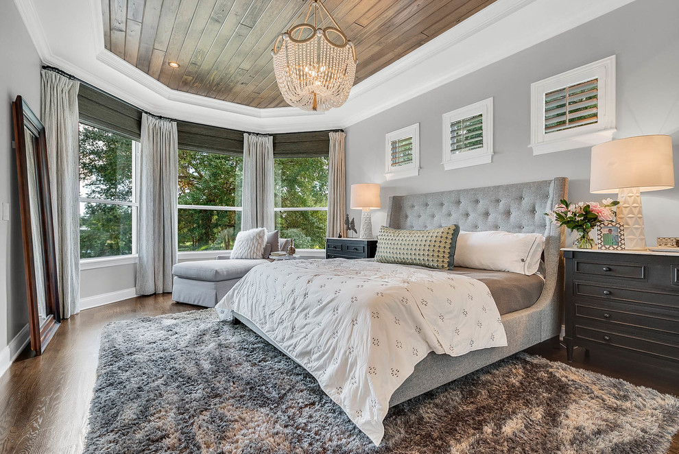 Design ideas for a large transitional master bedroom in Orlando with grey walls, medium hardwood floors, brown floor and no fireplace.