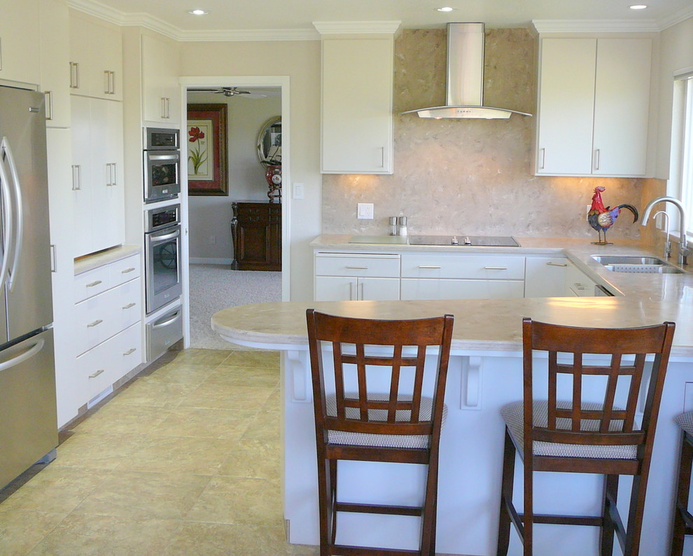 Inspiration for a transitional porcelain tile kitchen remodel in Sacramento with an undermount sink, flat-panel cabinets, white cabinets, solid surface countertops, beige backsplash and stainless steel appliances