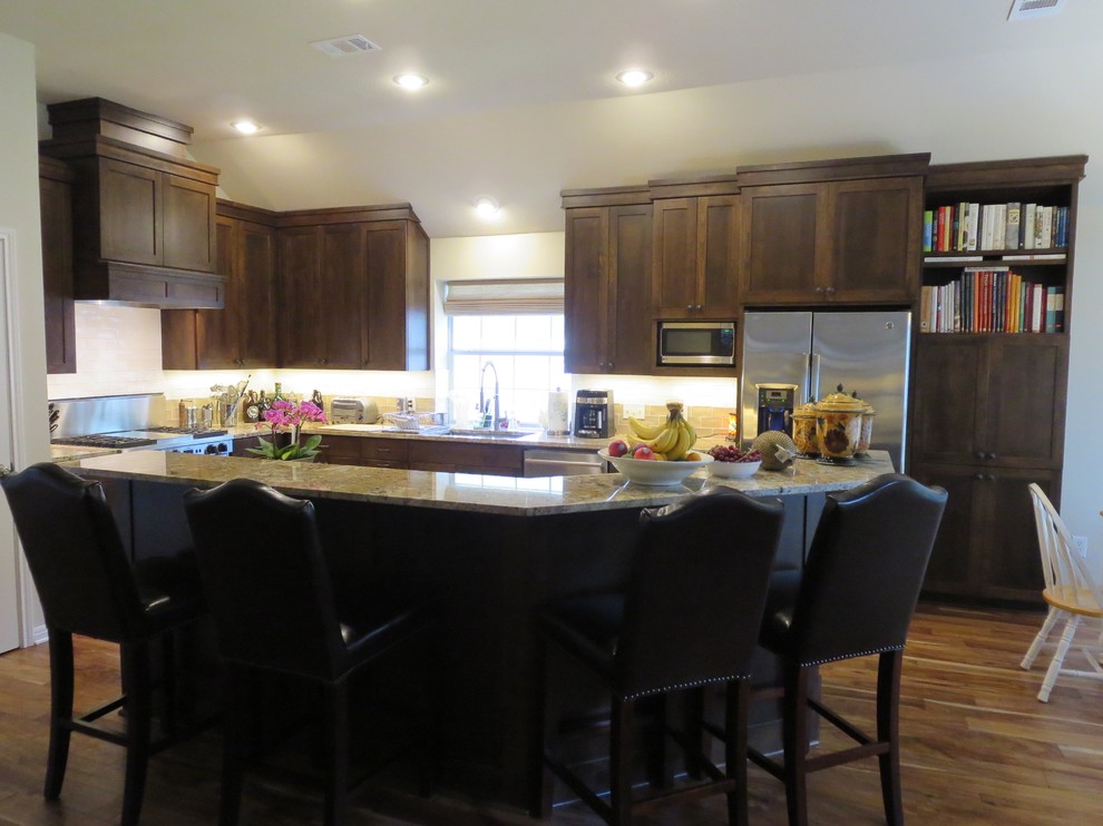 Eat-in kitchen - large transitional medium tone wood floor and brown floor eat-in kitchen idea in Austin with an undermount sink, shaker cabinets, dark wood cabinets, granite countertops, multicolored backsplash, ceramic backsplash, stainless steel appliances and an island
