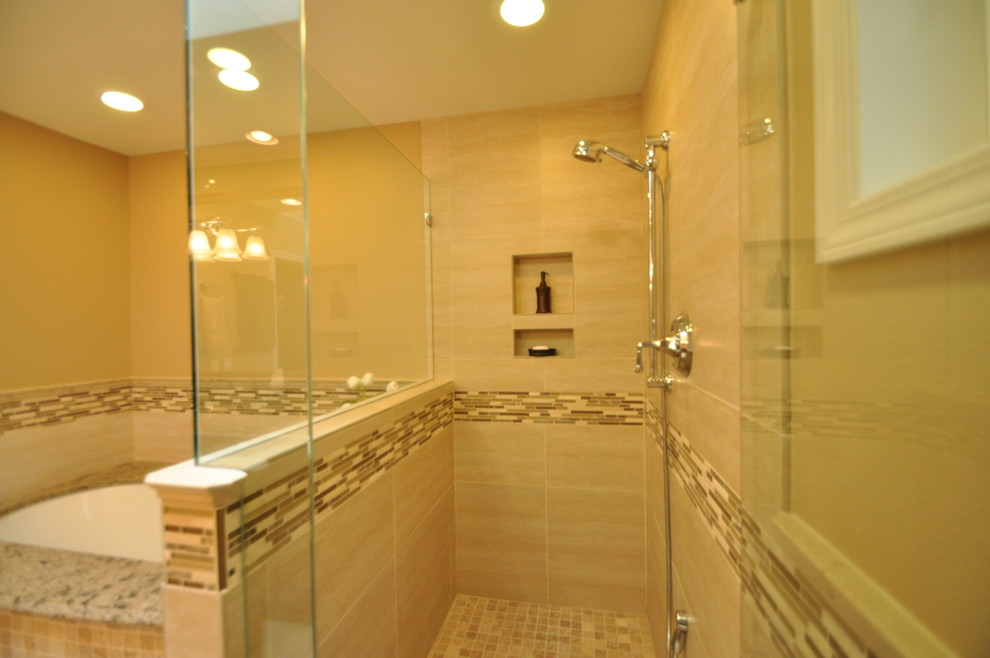 Photo of a mid-sized traditional master bathroom in Seattle with an undermount sink, raised-panel cabinets, medium wood cabinets, granite benchtops, an undermount tub, a corner shower, a two-piece toilet, beige tile, porcelain tile, beige walls and porcelain floors.