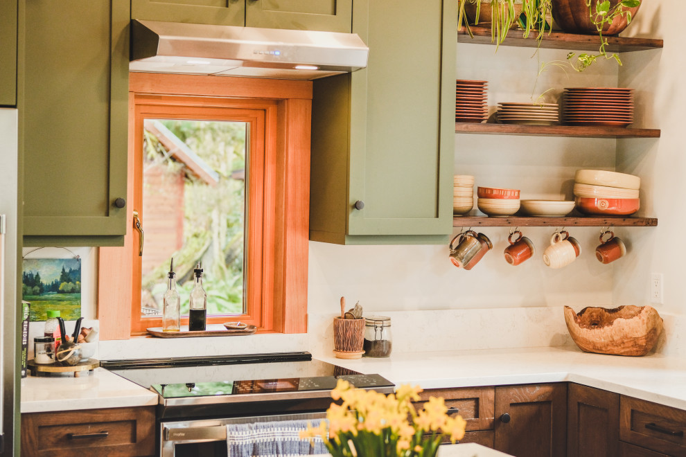 Bild på ett mellanstort amerikanskt vit vitt kök, med en undermonterad diskho, skåp i shakerstil, gröna skåp, bänkskiva i kvarts, vitt stänkskydd, rostfria vitvaror, mellanmörkt trägolv, en köksö och flerfärgat golv