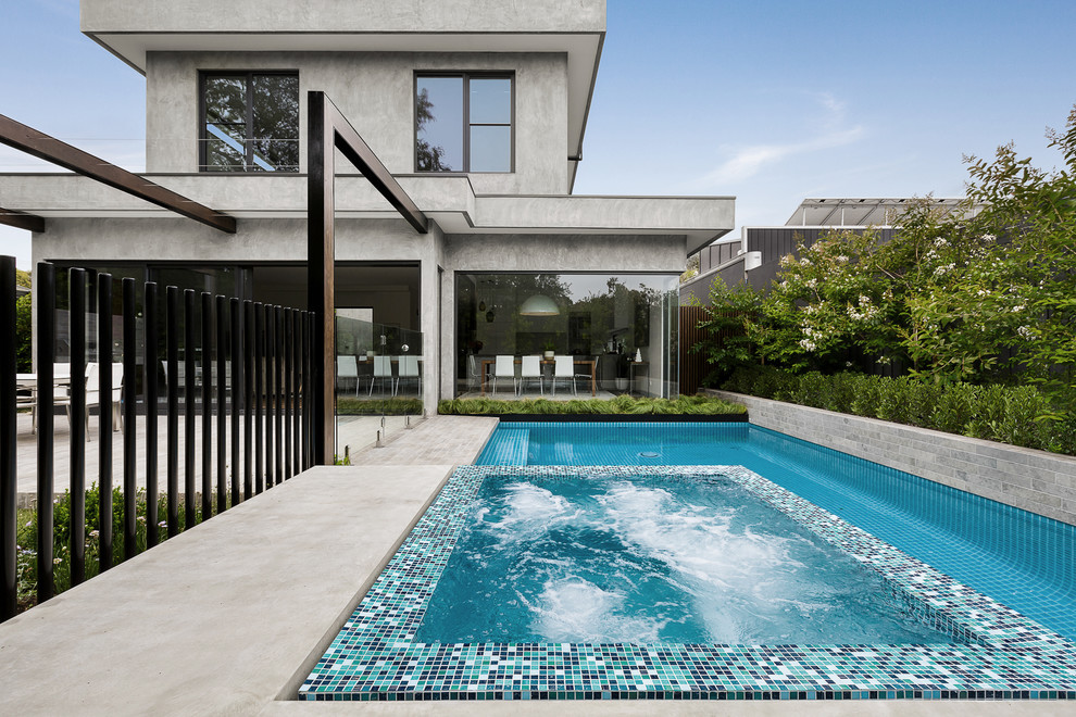 Photo of a large contemporary backyard rectangular infinity pool in Other with concrete slab.