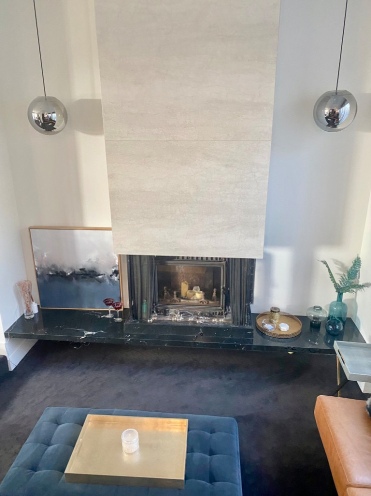 Photo of a large midcentury living room in Melbourne with carpet, a hanging fireplace and grey floor.