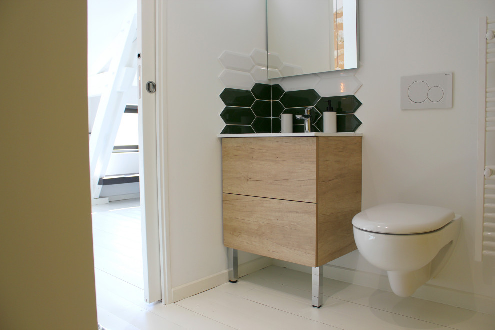 Design ideas for a small modern 3/4 bathroom in Other with beaded inset cabinets, light wood cabinets, a wall-mount toilet, green tile, ceramic tile, white walls, painted wood floors, a console sink, white floor, white benchtops, a single vanity, a freestanding vanity, a curbless shower and a hinged shower door.